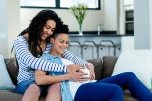 Smiling lesbian couple expecting a child