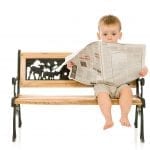 little boy reading a newspaper