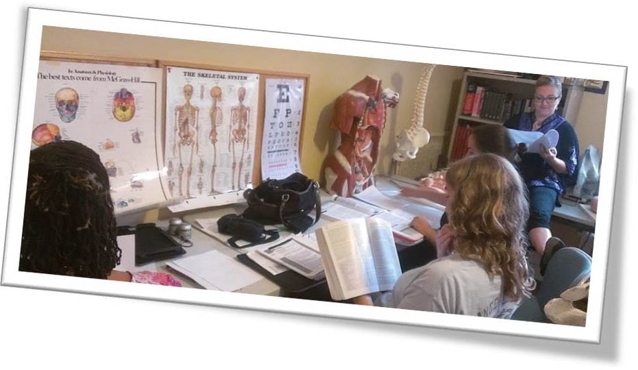 people reading medical and anatomical literature at a cluttered desk